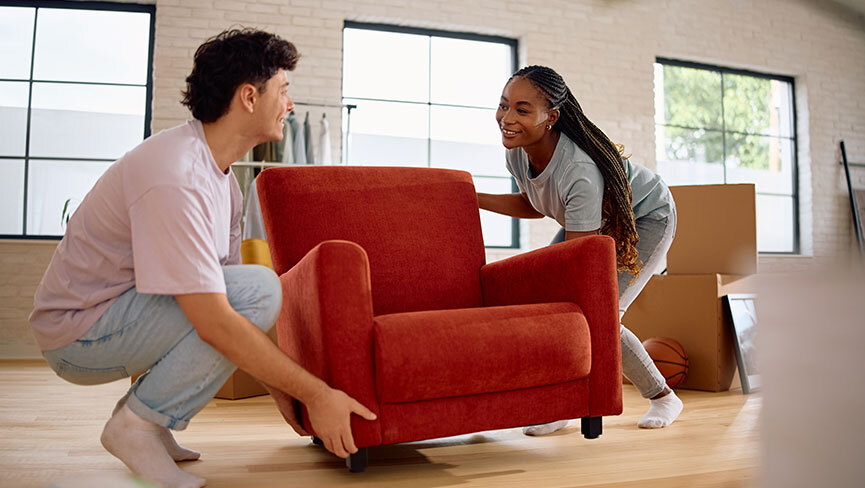 woman and man moving cushioned chair